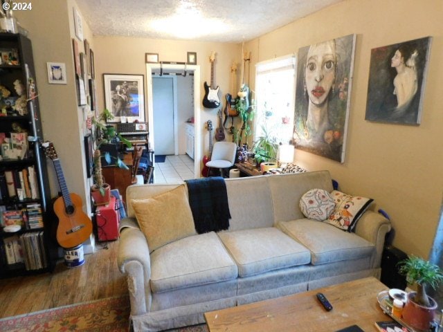 living room with a textured ceiling and light wood-type flooring