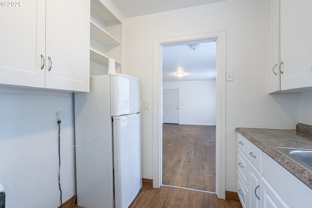 kitchen featuring white cabinets, white refrigerator, and dark hardwood / wood-style floors