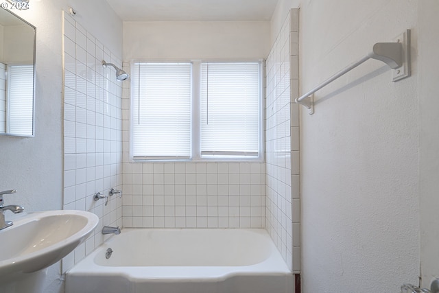 bathroom with tiled shower / bath combo and sink