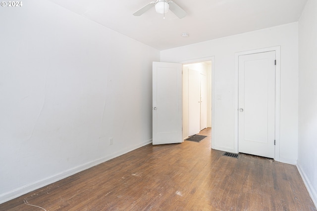 empty room with ceiling fan and dark wood-type flooring