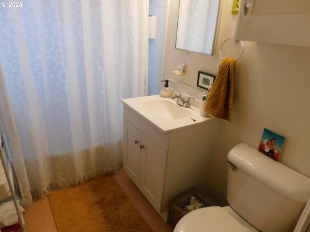 bathroom featuring walk in shower, vanity, and toilet