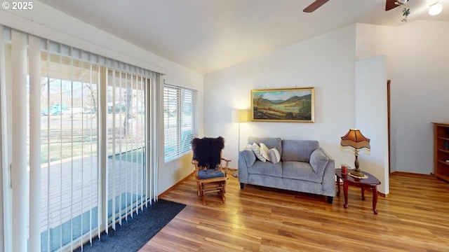 living area with hardwood / wood-style floors, vaulted ceiling, and ceiling fan