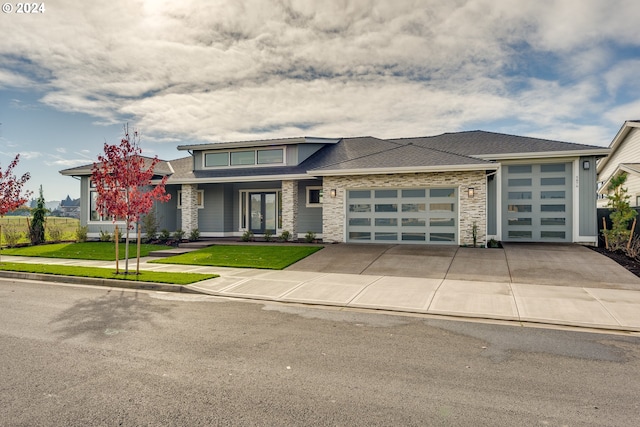 prairie-style house featuring a garage, a front yard, and french doors