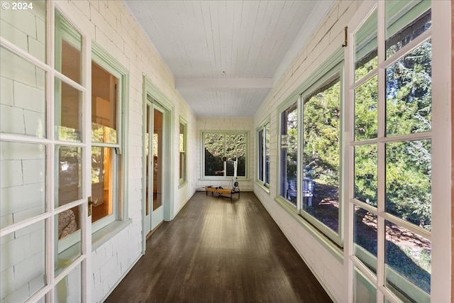 unfurnished sunroom featuring beam ceiling and wood ceiling