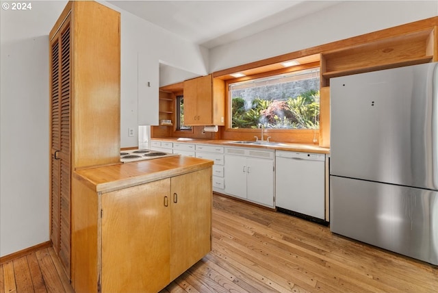 2626 SW Ravensview Dr, Portland, OR 97201 - kitchen with freestanding refrigerator, white dishwasher, a sink, light wood-type flooring, and white cabinetry