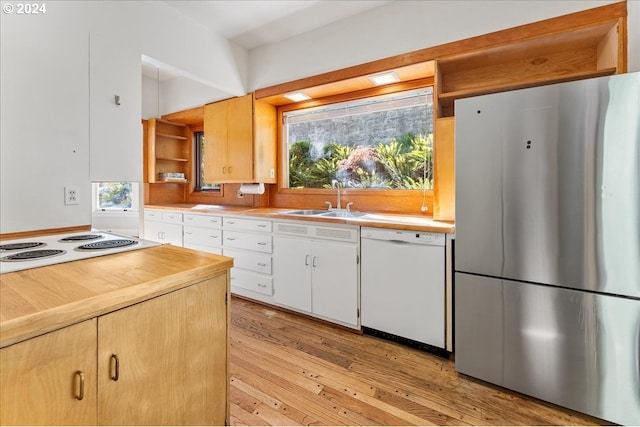 kitchen with white cabinetry, white appliances, sink, and light hardwood / wood-style flooring