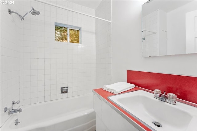 bathroom featuring vanity and tiled shower / bath