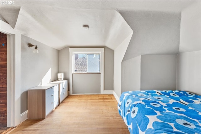 2626 SW Ravensview Dr, Portland, OR 97201 - bedroom with light wood finished floors, vaulted ceiling, and baseboards