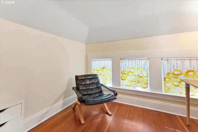 living area with wood-type flooring and vaulted ceiling