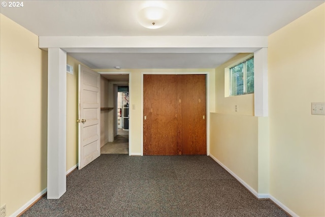 hall featuring dark colored carpet