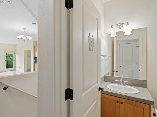 bathroom with vanity and a notable chandelier