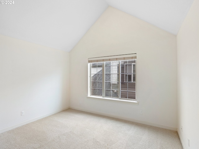 empty room with lofted ceiling and carpet floors