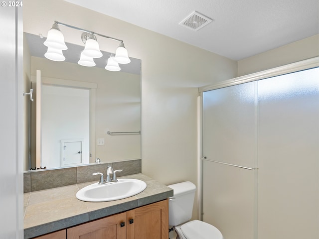 bathroom featuring vanity, toilet, a shower with door, and an inviting chandelier