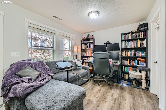 office area with a textured ceiling and light hardwood / wood-style flooring