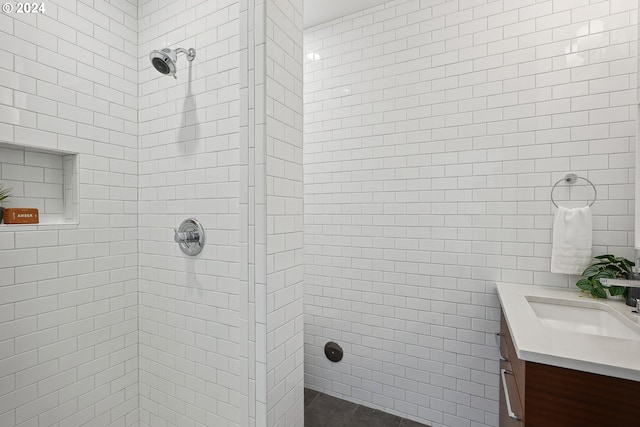 bathroom featuring a tile shower and vanity