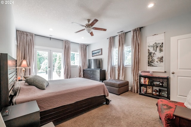 carpeted bedroom featuring french doors, ceiling fan, and a textured ceiling