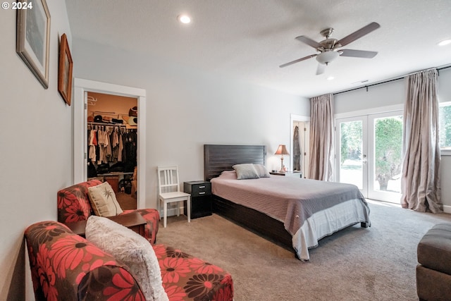 carpeted bedroom with a textured ceiling, a walk in closet, a closet, access to exterior, and ceiling fan