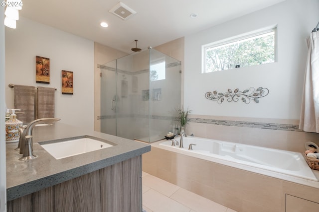 bathroom featuring independent shower and bath, vanity, and tile patterned flooring