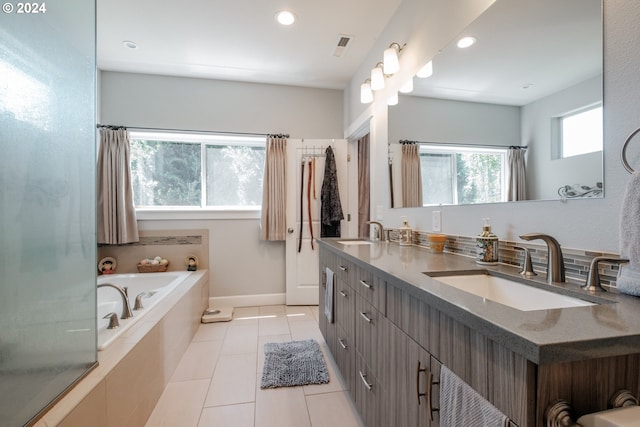 bathroom featuring tiled bath, vanity, and tile patterned floors