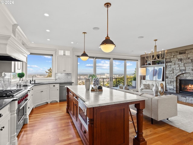 kitchen with stainless steel appliances, pendant lighting, a center island, and sink