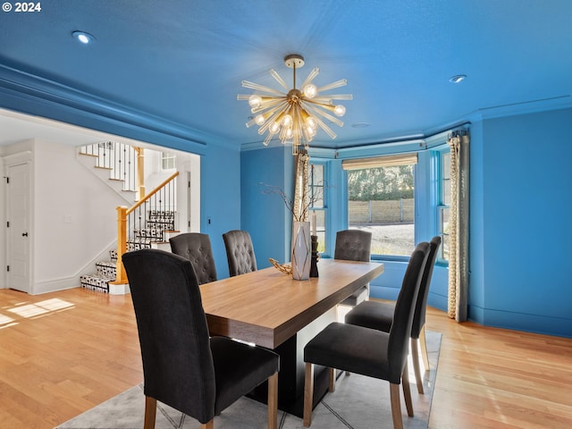 dining space with crown molding, a notable chandelier, and light wood-type flooring