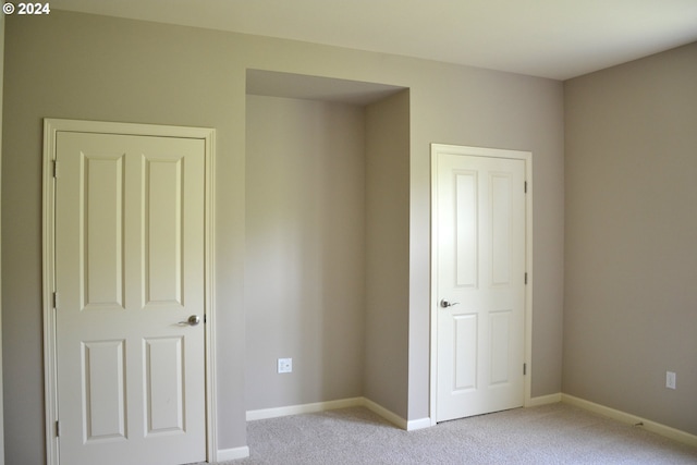 unfurnished bedroom featuring a closet and light carpet