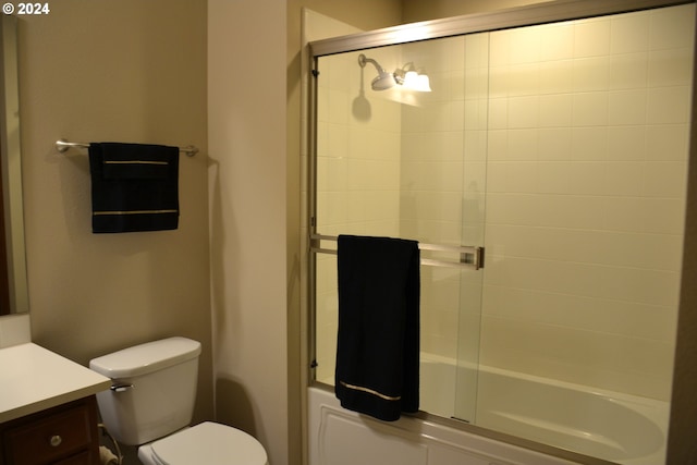 full bathroom featuring bath / shower combo with glass door, toilet, and vanity