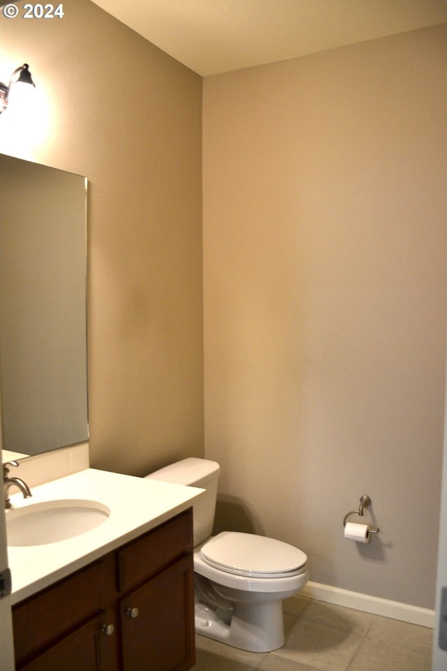 bathroom with toilet, tile patterned flooring, and vanity