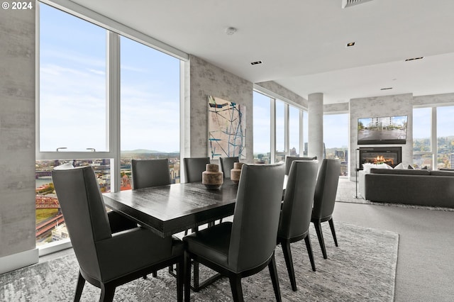 dining area with carpet floors and a large fireplace