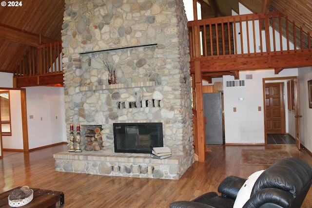 living room featuring high vaulted ceiling, dark hardwood / wood-style flooring, beamed ceiling, and a stone fireplace