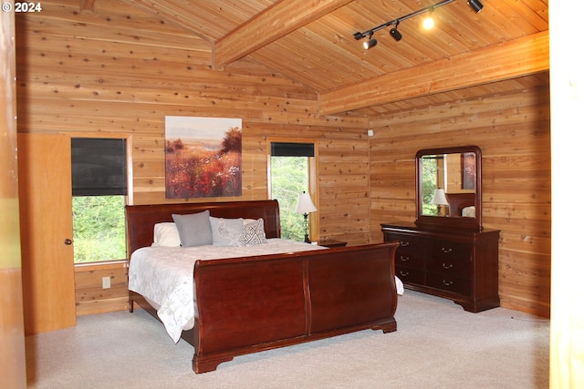 bedroom featuring wooden walls, vaulted ceiling with beams, light colored carpet, and rail lighting