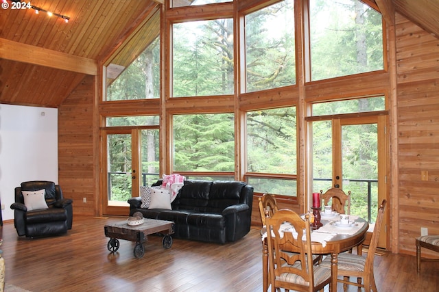 living room with french doors, wood walls, and wood-type flooring