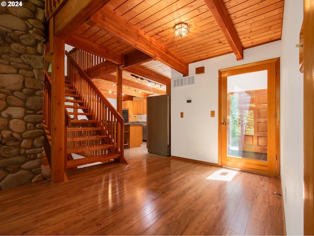 unfurnished living room with wood-type flooring, beamed ceiling, and wooden ceiling