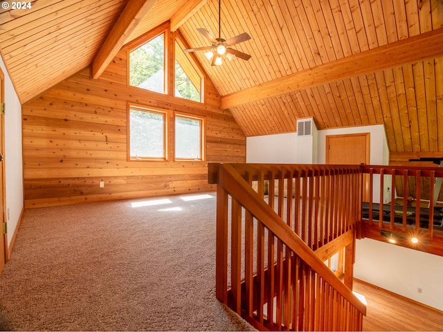 additional living space featuring lofted ceiling with beams, wood walls, wooden ceiling, wood-type flooring, and ceiling fan