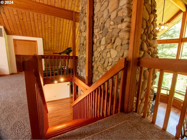 stairs featuring wood-type flooring, vaulted ceiling with beams, wood ceiling, and ceiling fan