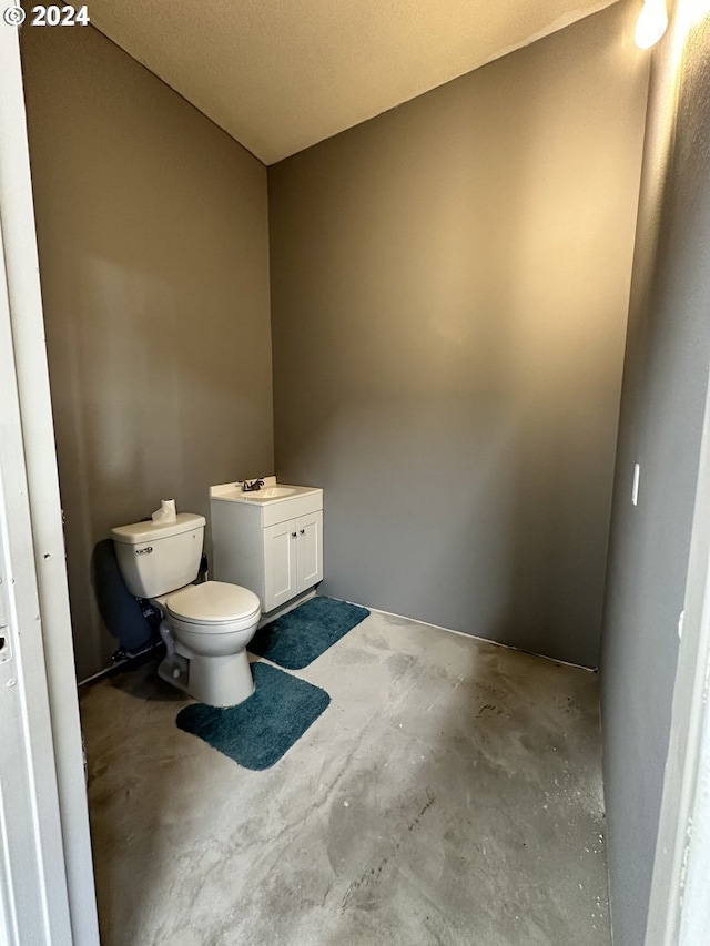 bathroom featuring vanity, toilet, and concrete floors