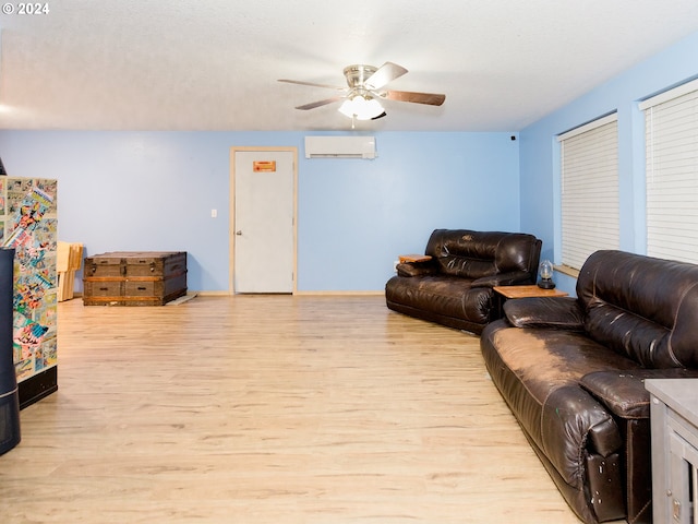 living room with an AC wall unit, ceiling fan, light wood-style flooring, and baseboards