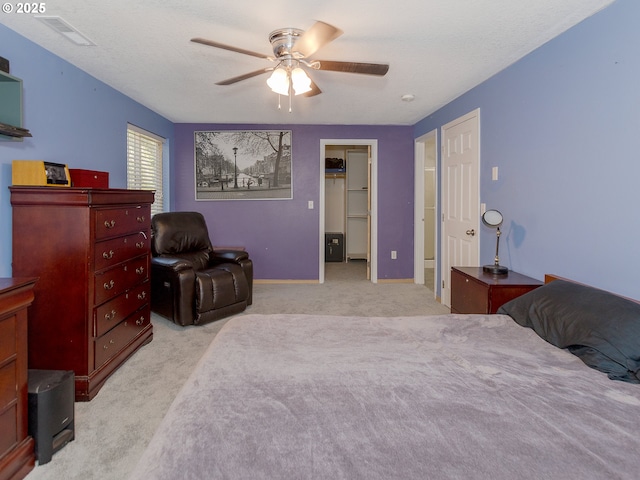 bedroom with a ceiling fan, visible vents, light carpet, and baseboards