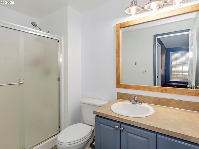 bathroom with toilet, a shower stall, and vanity