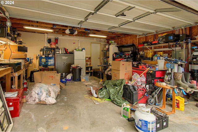 garage featuring a workshop area, freestanding refrigerator, and a garage door opener