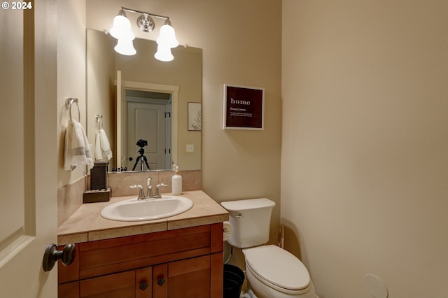 half bathroom featuring vanity and toilet