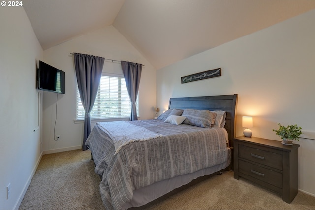 bedroom featuring light carpet, lofted ceiling, and baseboards