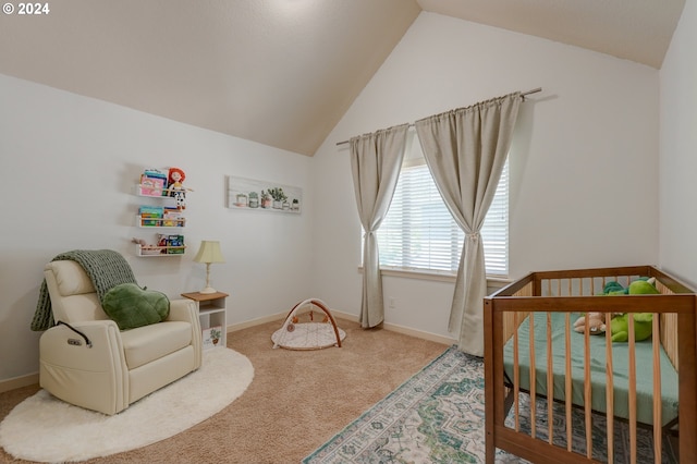 bedroom featuring vaulted ceiling, a crib, baseboards, and carpet