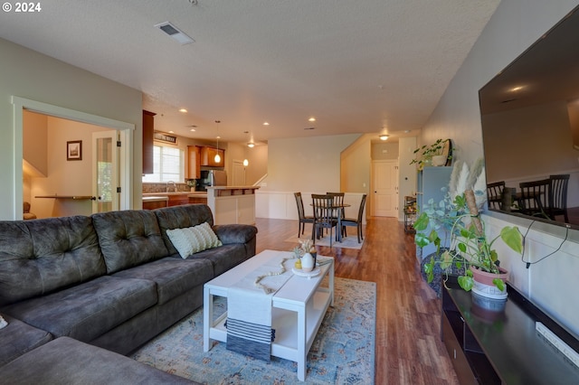 living room featuring wood finished floors, visible vents, and recessed lighting