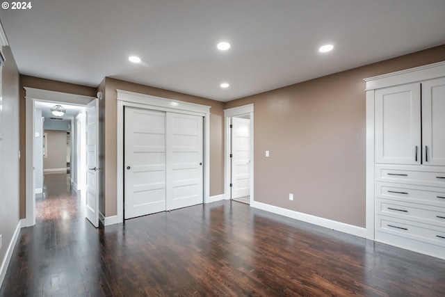 unfurnished bedroom featuring dark hardwood / wood-style flooring and a closet