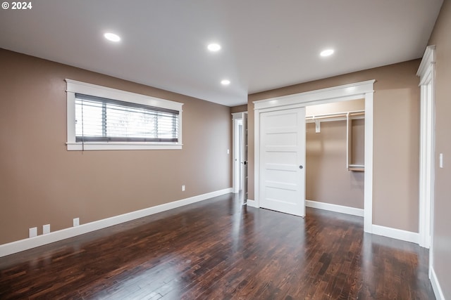 unfurnished bedroom with dark wood-type flooring and a closet