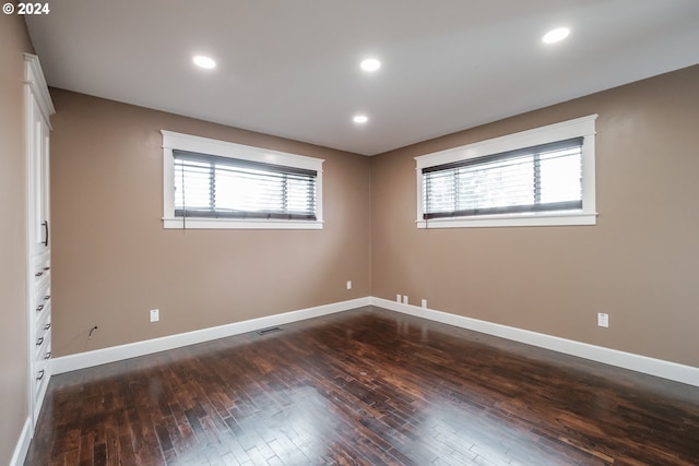 spare room featuring plenty of natural light and dark hardwood / wood-style floors