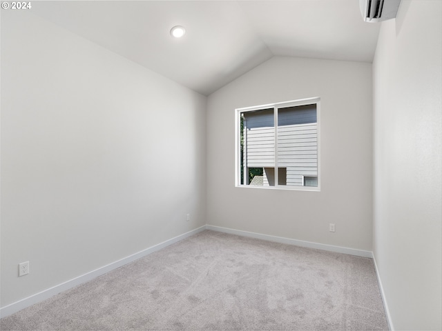 carpeted empty room with vaulted ceiling and a wall mounted AC