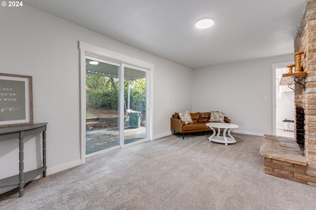 living area with carpet and a fireplace