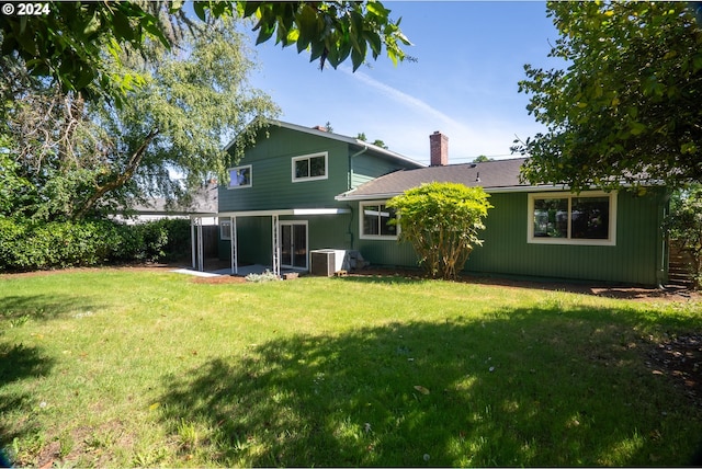 rear view of property featuring a yard and a patio area